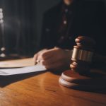 Law,Books,And,Scales,Of,Justice,On,Desk,In,Library