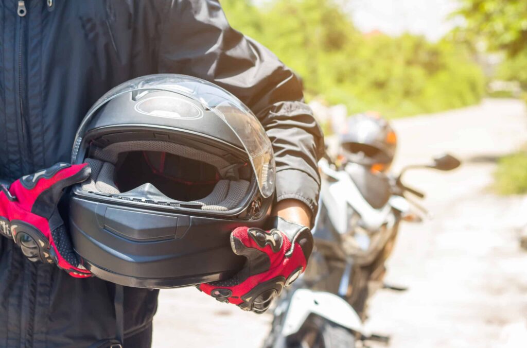 Man in a Motorcycle with helmet and gloves is an important prote